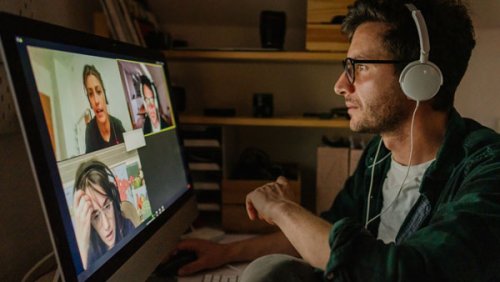 A man with headphones on a zoom call