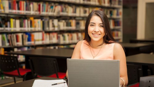 Woman in a library working in her computer