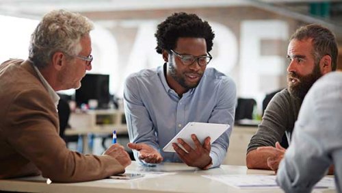 Group of people having a chat while one of them looks at his tablet