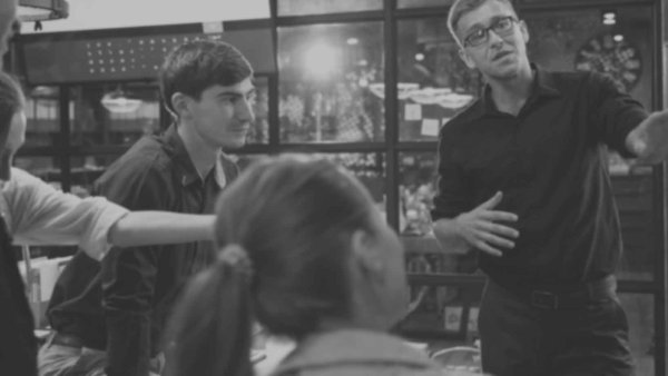 Group of people having a discussion and one of them is pointing at something