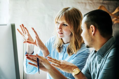 two people looking at the computer and talking