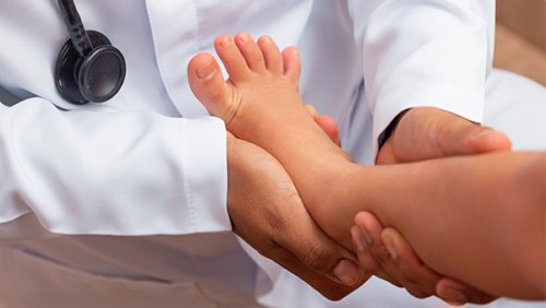 Doctor checking a kids's feet
